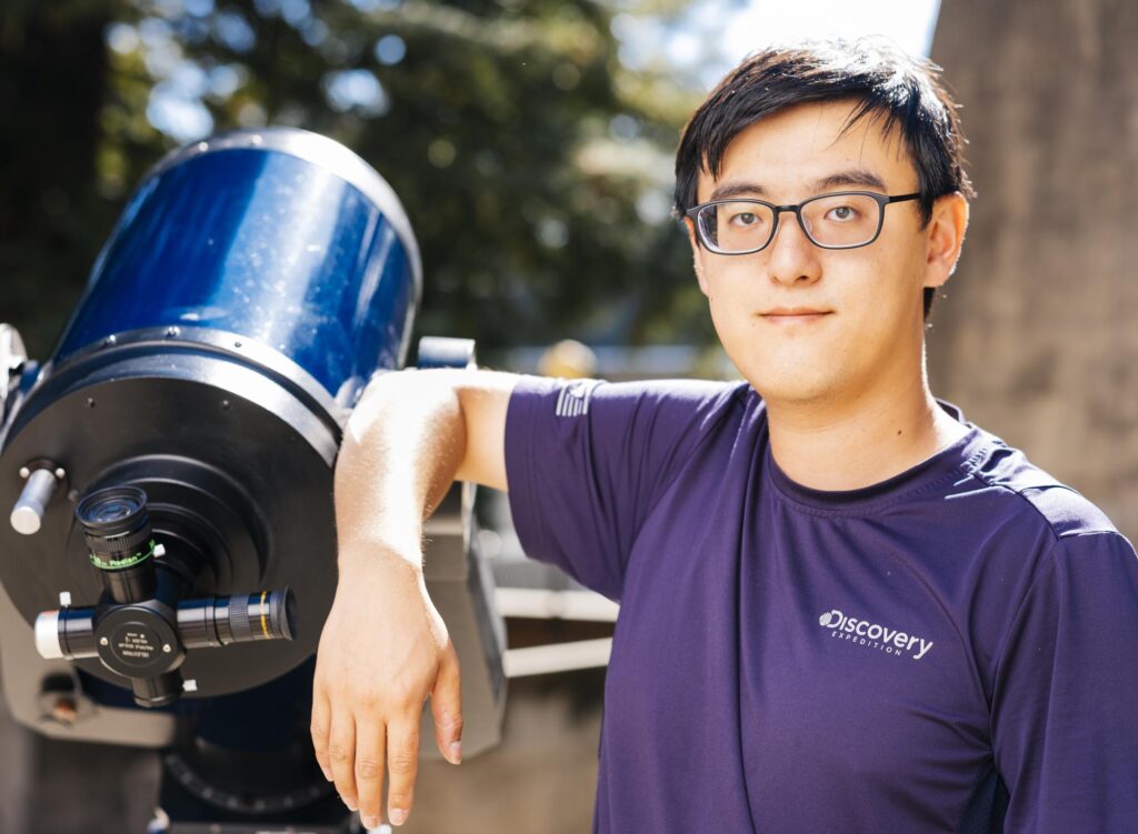 Portrait of a post doc and a telescope.