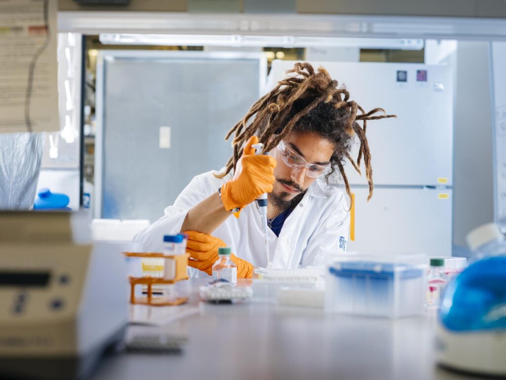 Student working in a lab using a pipette