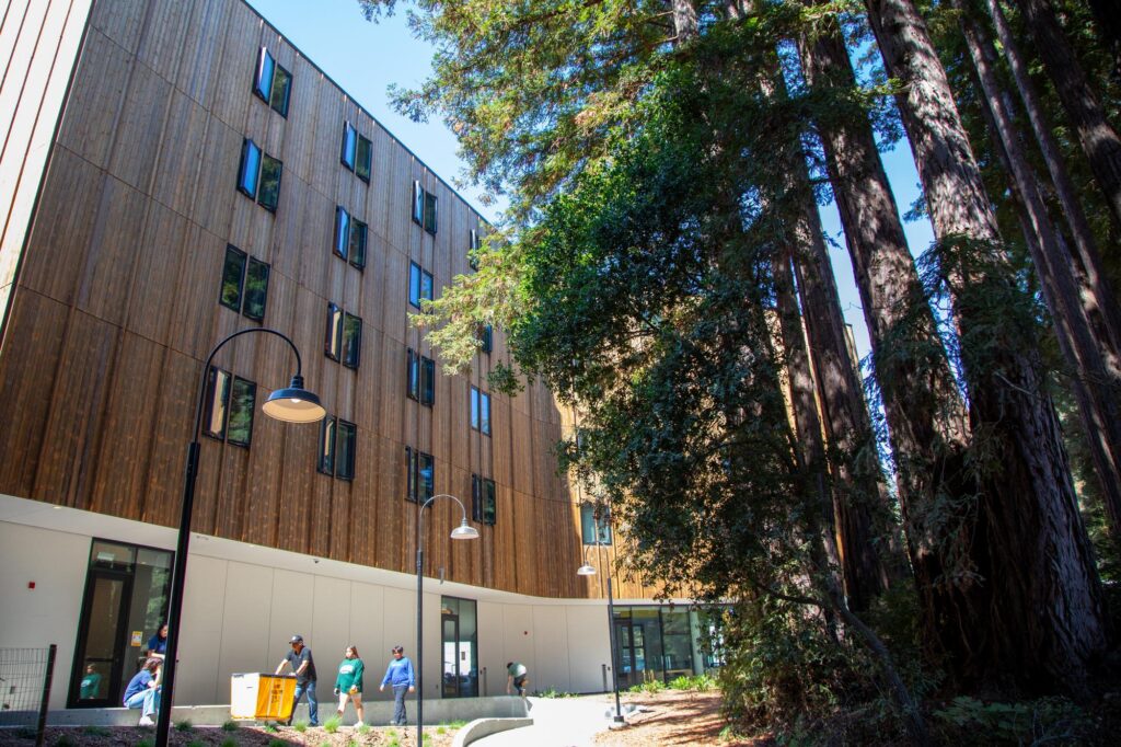 Exterior of Kresege College with redwood trees and families moving their daughter in to the residential colleges