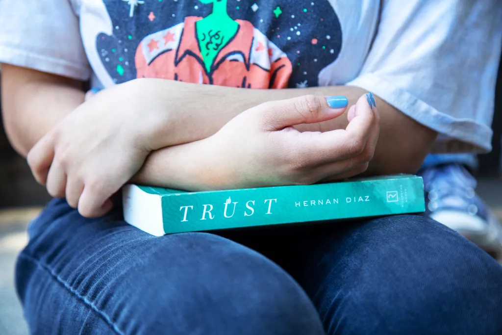 A student holds a copy of The Humanities Institute’s 2024 Deep Read selection, Hernan Diaz’s Pulitzer Prize–winning novel Trust. UCSC students explored the book and Diaz’s other writings in a course with Lecturer and THI Program Manager Laura Martin. Photo by Carolyn Lagattuta