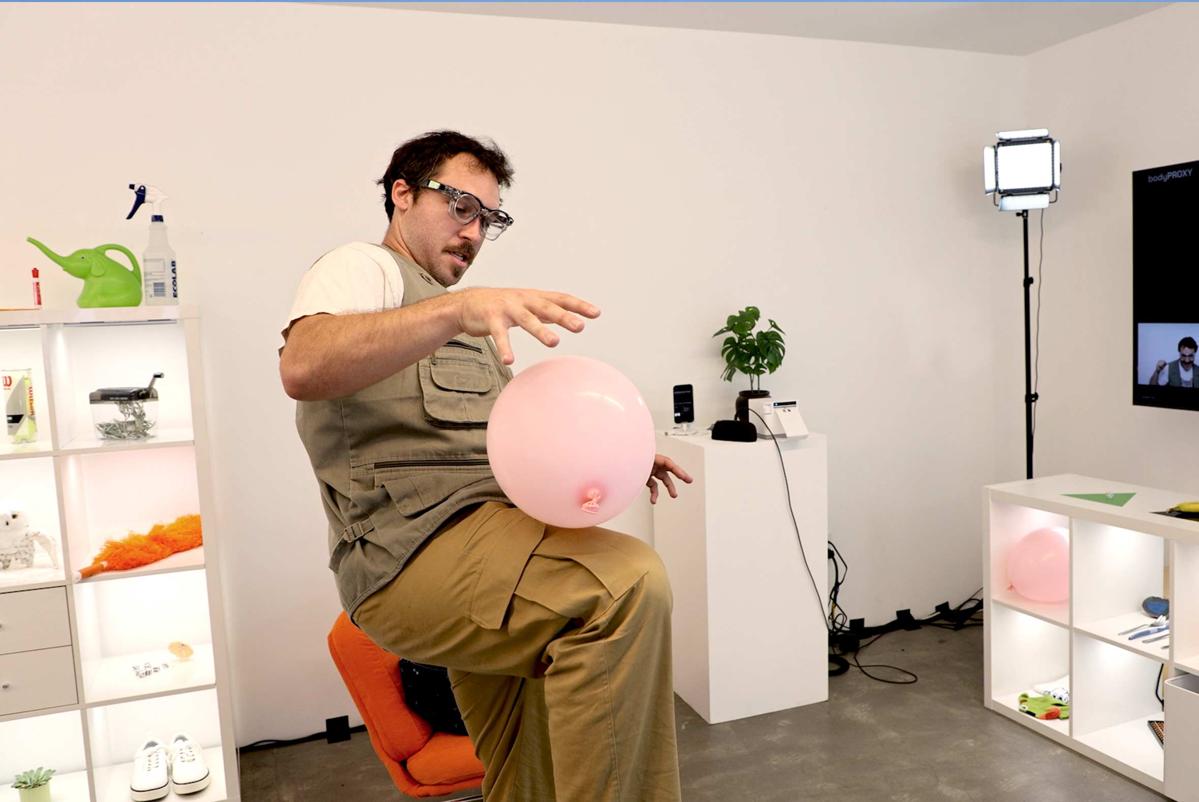 A man bounces a pink balloon off of his knee
