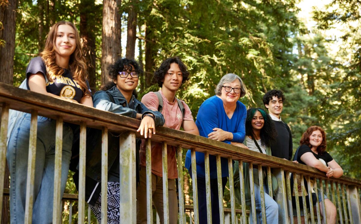 Chancellor Cythia Larive smiles with the students on the wooden bridge